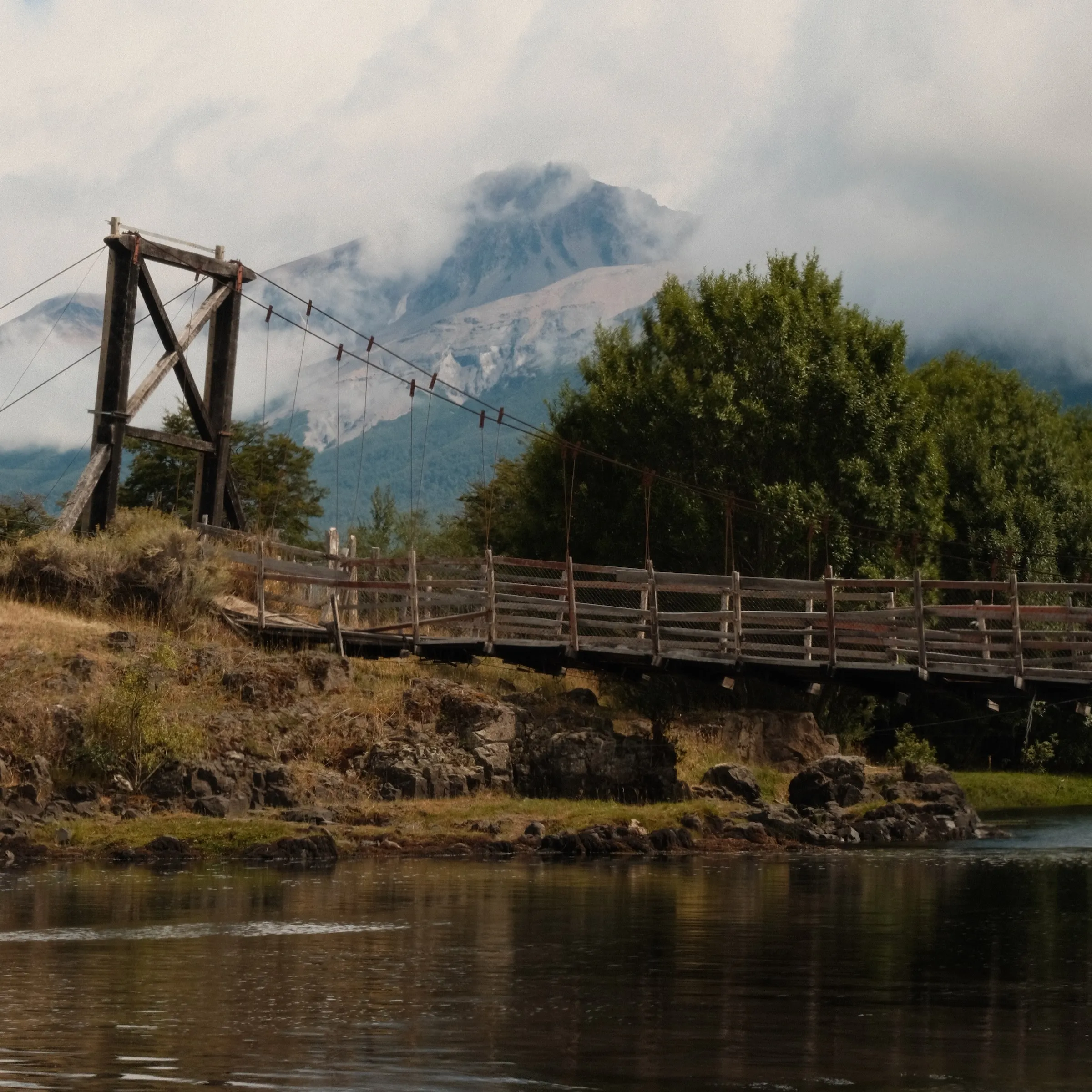 Wooden suspension bridge over the Nirehuau, mountain behind