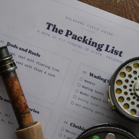The printed packing list on a table with a fly rod and reel